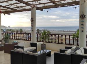 a patio with chairs and a view of the beach at Hotel Nuevo Amanecer Malabrigo in Puerto Chicama