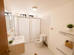 a white bathroom with a toilet and a sink at Casa en Huatulco Casa para 6 Personas Cerca del Centro y Playas in Santa Cruz Huatulco
