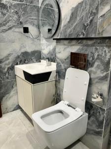 a bathroom with a white toilet and a sink at Landmark Hotel & Resort in Taiwāl