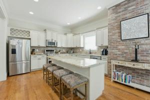a kitchen with white cabinets and a brick wall at The Classy Craftsman - Beautiful Decor & Pool in Atlanta