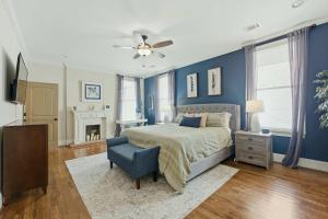 a bedroom with blue walls and a bed and a chair at The Classy Craftsman - Beautiful Decor & Pool in Atlanta +34 photos