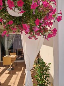 a white vase filled with pink flowers in a room at b&b Civico 30 in Lonato