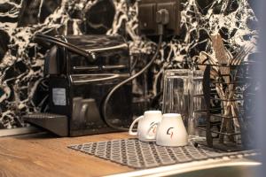 a counter with two coffee mugs on a keyboard at Villa Theodora Boutique Stay in Fanari