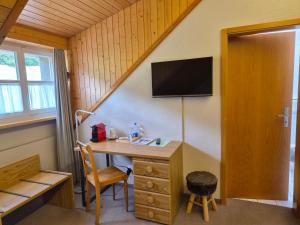 a room with a desk with a tv on the wall at Landgasthaus Bären in Grub