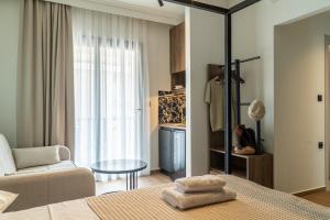 a bedroom with a bed and a table and a couch at Villa Theodora Boutique Stay in Fanari