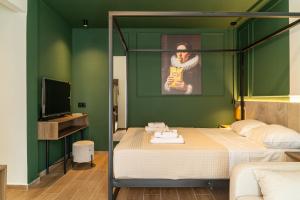 a bedroom with a bed with a green wall at Villa Theodora Boutique Stay in Fanari