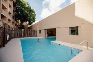 a person in a swimming pool next to a building at Nativo Lodge in Albuquerque