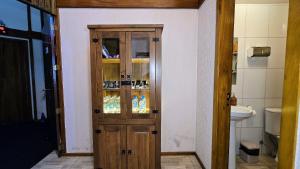 a bathroom with a wooden door and a toilet at Residencial Borges Canela in Canela +95 photos