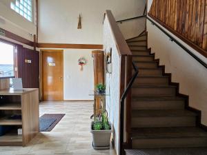 a hallway with a staircase with two potted plants at Residencial Borges Canela in Canela