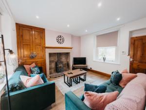 a living room with two couches and a fireplace at Peak Cottage in Matlock