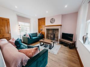 a living room with a couch and a fireplace at Peak Cottage in Matlock +22 photos
