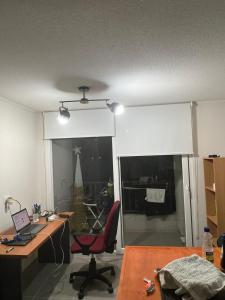an office with a desk and a chair and a window at Urbano Talca in Talca