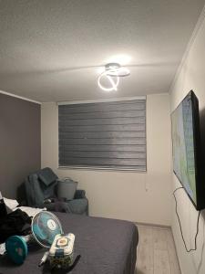 a room with a bed and a flat screen tv at Urbano Talca in Talca