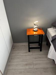 a table with a lamp on it next to a bed at Urbano Talca in Talca