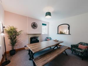 a living room with a wooden table and a fireplace at Peak Cottage in Matlock