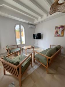 a living room with two beds and a tv at Dar Lisa - Charming authentic beachfront villa in Aghīr