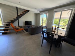 a living room with a table and a staircase at Gite le3chênes in Remoncourt