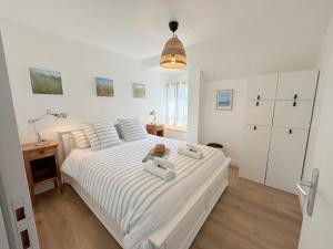 a bedroom with a large white bed with a hat on it at Ty kergo in Surzur