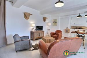 a living room with a leather couch and chairs at Ty kergo in Surzur