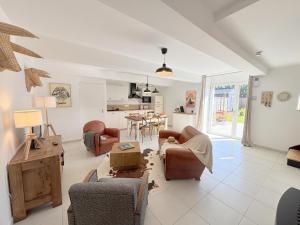 a living room with chairs and a table and a kitchen at Ty kergo in Surzur