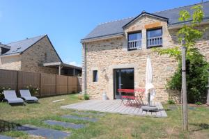 a brick house with a patio and an umbrella at Ty kergo in Surzur