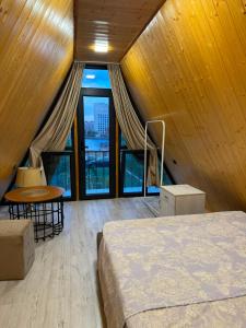 a bedroom with a bed and a table and windows at Eco Villa, A frame with barbecue zone and pool in Yerevan +23 photos