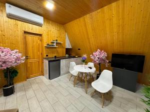 a kitchen with a table and chairs and a tv at Eco Villa, A frame with barbecue zone and pool in Yerevan