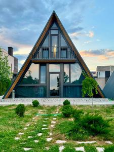 a house with a triangular roof with glass windows at Eco Villa, A frame with barbecue zone and pool in Yerevan