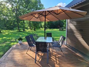 a table and chairs with an umbrella on a deck at Riverside Sauna House in Savala