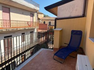 a blue chair sitting on the balcony of a building at Casa Caterina in Graniti