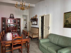 a living room with a table and a green couch at Casa Caterina in Graniti