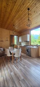 a kitchen and dining room with a table and chairs at Guesthouse Turo in Ambrolauri