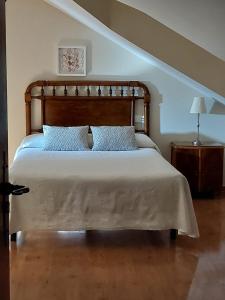a bedroom with a large bed with blue pillows at Casa Rural Maria in Molinaseca