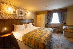 a hotel room with a bed and a window at The Red Lion Hawkshaw in Bury