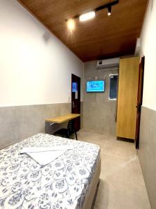 a room with a bed and a desk in it at Hotel Pousada da Praia in Recife
