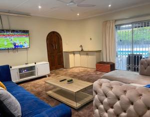 a living room with a couch and a tv at Blue Bend Valley in East London
