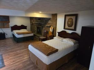 a hotel room with two beds and a fireplace at Huntingdon Inn in Irwin