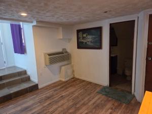 an empty living room with a stairs and a heater at Huntingdon Inn in Irwin