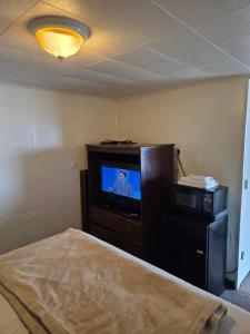a bedroom with a tv and a bed in a room at Huntingdon Inn in Irwin