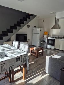 a living room with a kitchen and a staircase at Casa Cris Pinamar in Pinamar