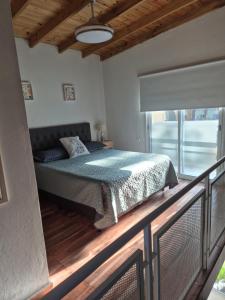 a bedroom with a bed and a balcony at Casa Cris Pinamar in Pinamar