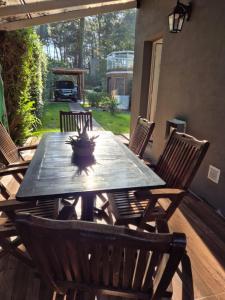 a wooden table and chairs on a patio at Casa Cris Pinamar in Pinamar +9 photos