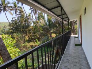 a balcony with a view of the forest at Eva Beach Side Room in Mandrem