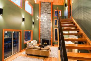 a living room with a staircase and a fireplace at Whistler Peak Lodge in Glacier