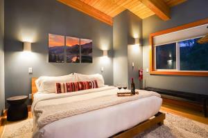 a bedroom with a large bed with two paintings on the wall at Whistler Peak Lodge in Glacier