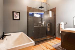a bathroom with a shower and a sink and a tub at Whistler Peak Lodge in Glacier +35 photos