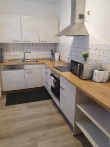 a kitchen with a counter with a microwave and a sink at ST4 Apartment in Triberg