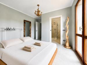 a bedroom with a large white bed with towels on it at Villa dei Mumi in Luino