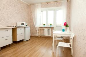 チュメニにあるHappy Apartments on Semenova 31の白いキッチン(テーブル付)