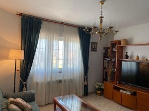 a living room with a couch and a television at Finca la Tierruca de Cudon in Cudón